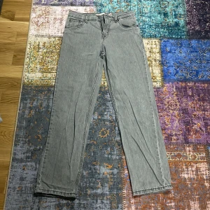 Levi's 514 grå jeans loose fit - Grå Levi's 514 jeans med loose fit och raka ben. Klassisk femficksmodell med svarta sömmar och Levis-patch bak. Jeansen är tillverkade i denim och har en avslappnad passform som ger en chill vibe.