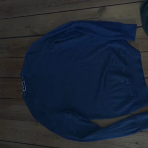 Blå stickad tröja Charles Tyrwhitt - Snygg marinblå stickad tröja från Charles Tyrwhitt i storlek small. Tröjan har rund hals, lång ärm och är tillverkad i mjuk merinoull som känns riktigt skön mot huden. Perfekt för dig som gillar stilrena och klassiska plagg med modern vibe.