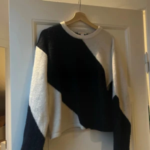 Svartvit stickad tröja Gina Tricot - Säljer en stickad tröja från Gina Tricot i storlek 170. Tröjan har ett coolt diagonalt mönster i svart och vitt, rund hals och långa ärmar. Materialet är mjukt och mysigt, perfekt för att hålla sig varm under kyliga dagar.