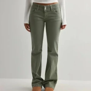 Bootcut gröna jeansbyxor - Snygga gröna jeansbyxor med bootcut-snitt och klassisk femficksdesign. Byxorna har normal passform och stängs med dragkedja och dubbla knappar i midjan. Perfekta för dig som gillar en stilren look med lite extra edge.