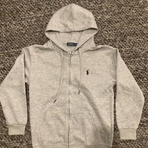 Ralph Lauren Zip Hoodie - En riktigt snygg Zip Hoodie från Ralph Lauren, jag säljen den eftersom jag fick den i present och passade inte mig storleksmäsigt. Den är en Medium men sitter lite mer som en Small. Jag kan gå ner i pris vid snabb afär. Tveka inte att höra av dig. 