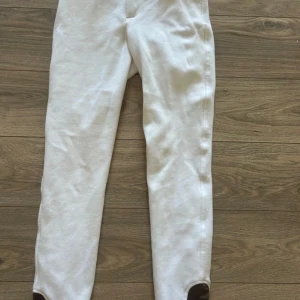 Vita ridbyxor med knäskoning - Snygga vita knäskodda ridbyxor som passar perfekt till träning och tävling. Stretchigt material som ger bra passform och komfort. Perfekta för dig som vill sticka ut lite extra i stallet. 