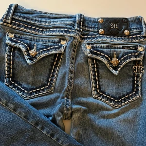 Miss Me blå bootcut jeans med broderi - Snygga blå jeans från Miss Me med bootcut passform. Säljer om eftersom de inte kommit till användning och köpta på vinted där av kommer priset.                                                                         De har lite defekter som syns på de sista bilderna. En knapp saknas och det är hål vid bakfickan på jeansen men inget som syns tydligt ❣️