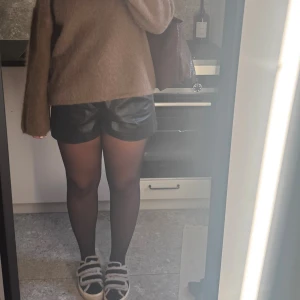 Svarta skinnshorts från Zara - Snygga svarta shorts i skinnimitation från Zara med hög midja och stilrena fickdetaljer både fram och bak. Så snygga!!