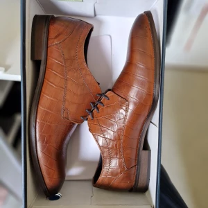 Oanvända Läder skor Storlek 44 - Helt nya i kartongen. Storlek 44 Krokodilmönstrat läder. Kan hämtas på plats i Uppsala eller skickas mot porto. OBS: Inga byten eller returer