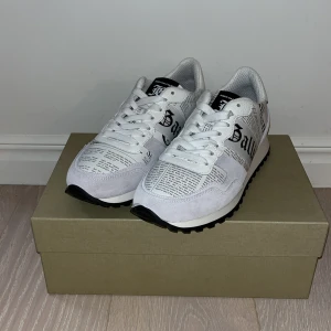 John Galliano vita sneakers med print - Tjena! Nu säljer vi dessa feta John Galliano skor med speciell design av artiklar. Helt nya och har inte kommit till användning. Skick 10/10 med box