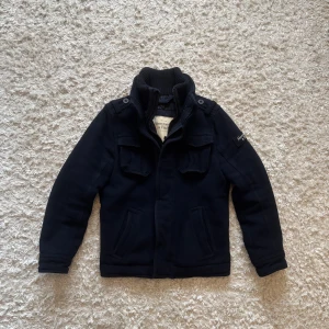 Blå jacka från Abercrombie & Fitch - Riktigt snygg marinblå jacka från Abercrombie & Fitch, den är faktiskt ganska tjock och varm så den passar perfekt nu till hösten/vintern. Storlek S i bra skick, ända defekten är att den är lite knottrig i kragen. Tveka inte på o skriva vid fler frågor!