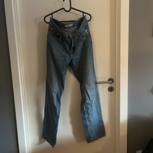 Blå raka jeans från Pull&Bear - Säljer ett par klassiska blå jeans från Pull&Bear med rak passform och normal midja. Jeansen har fem fickor, gylf med dragkedja och knapp, samt snygga kontrastsömmar. 