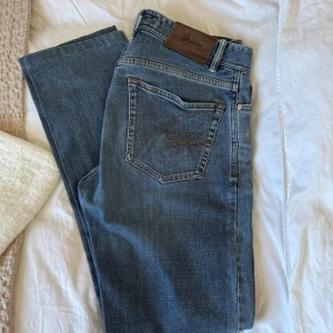 Brioni Jeans - Grymt snygga jeans från Brioni, som tillverkar kläder i absolut världsklass! Rak passform med märkets B broderat på bakfickan. Mer exklusiva jeans är svårt att hitta. Jeansen är i absolut toppskick och köptes nya av mig. Nypris ca 10.000kr. Tveka inte att höra av er vid eventuella frågor eller funderingar!