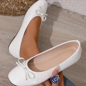 Vita ballerinaskor med rosett - Söta vita glansiga ballerina skor. Använd endast 2 ggr. Var för små för mig och tänker att jag säljer dem nu då verkligen alla ballerina skor är slutsålt inför somrarna💗