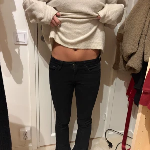 Svarta bootcut jeans - Säljer ett par svarta jeans med bootcut-modell och låg midja. Jeansen har klassiska fem fickor och smal passform upptill som går ut lite vid benslutet. Perfekta för dig som gillar en tidlös och clean look.