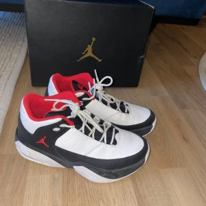 Nike Air Jordan 2 sneakers vit/svart/röd - Säljer ett par Nike Air Jordan 2 sneakers i vitt, svart och rött. Skorna har klassisk snörning, röd insida och detaljer, samt en robust sula. Perfekta för dig som gillar streetstyle och vill sticka ut med en ikonisk modell.