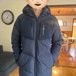 Mörkblå dunjacka från Sail Racing - Modellen är 183 cm lång, passar bra och är varm 