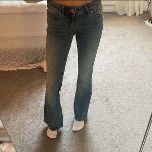 Bootcut jeans från Vero Moda XS - Snygga blå bootcut jeans från Vero Moda i storlek XS/30. Låg midja och lätt slitna detaljer framtill. Tillverkade i mjukt denim med dragkedja och knapp. Inte alls använda många gånger så säljer då de inte kommer till användning 