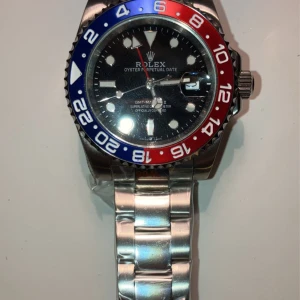 Klocka  - Automatisk klocka i fint skick. Rostfritt stål med svart boett och en röd, blå krona runtom. Skriv vid frågor⭐️