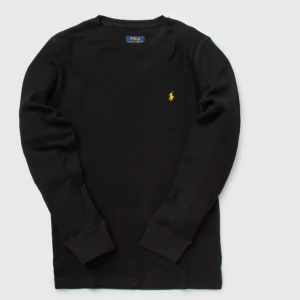 Svart långärmad tröja Polo Ralph Lauren - Svart långärmad tröja från Polo Ralph Lauren med klassisk gul broderad logga på bröstet. Tröjan har rund halsringning och är tillverkad i mjuk bomull med ribbade muddar vid ärmslut och nederkant. Perfekt för en clean och stilren look.i mycket fint skick använd någon gång 