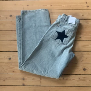 Ljusblå jeans med stjärnor Subdued - Ljusblå raka jeans från Subdued med coola svarta stjärnor på bakfickorna. Jeansen har normal midja, klassisk femficksdesign och är tillverkade i bomullsdenim. Aldrig använda, säljer pågrund av förlusten storlek. Nypris 900kr.