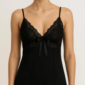 Svart spetsig linnetopp med rosett - Säljer en svart linnetopp med tunna axelband och vacker spetsdetalj över hela toppen. Toppen har en söt rosett framtill och djup v-ringning. Spetsen ger en lyxig känsla och toppen är perfekt för dig som gillar en feminin och trendig stil.