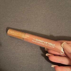 Isadora Glossy Lip Treat Ginger Glaze - Säljer Isadora The Glossy Lip Treat i färgen 54 Ginger Glaze. Det är ett återfuktande läppglans i en nude-brun nyans med glansig finish. Kommer i en smidig tub med applikator, perfekt att ha i väskan för snygga, glossiga läppar.