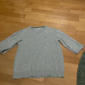 Ljusgrå tröja från GANT - Pris kan diskuteras ! Säljer en stilren ljusgrå stickad tröja från GANT med diskret logga på bröstet. Tröjan har rund halsringning, ribbade muddar och långa ärmar. Perfekt för dig som gillar klassisk och enkel stil.