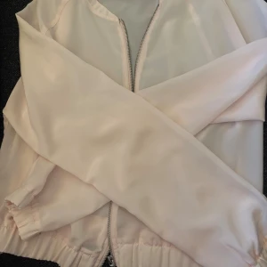 Ljusrosa bomberjacka från Gina Tricot - Säljer en ljusrosa bomberjacka från Gina Tricot i storlek 38. Jackan har dragkedja framtill, resår vid ärmslut och midja samt en stilren, enkel design. Perfekt för dig som gillar en clean look.