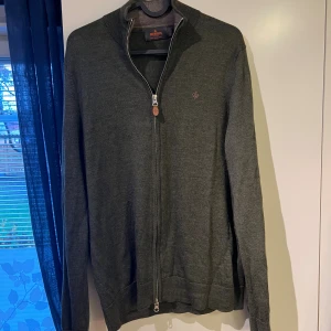 Olivgrön merinoullströja från Morris strl M - Tja! Säljer nu denna riktigt snygga olivgröna merinoullströjan då jag har växt ur den. Tröjan har fullzip dragkedja med läderdetalj och diskret logga på bröstet. Passar till otroligt många tillfällen. Tröjan är strl M, men har krympt i tvätten så sitter mer som S. Tröjan är fortfarande i väldigt gott skick! Nypris: 1999. Mitt pris: 650.