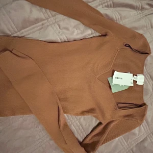 Beige ribbad långärmad topp H&M XS - Säljer en beige ribbad långärmad topp från H&M i storlek XS. Toppen har en snygg v-ringning och är figurnära i modellen. Materialet är en mix av viskos och syntet vilket gör den mjuk och stretchig. Perfekt att styla med jeans eller kjol.