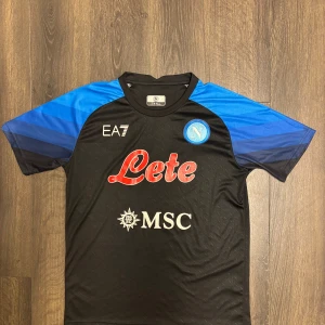 Napoli fotbollströja - Säljer en snygg Napoli fotbollströja i storlek S, kan passa M. Tröjan är i mycket bra skick och har inga defekter, använd endast ett par gånger.  Hör av er vid fler funderingar!