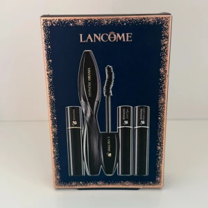 Lancôme Hypnôse Drama Mascara Set - Snyggt presentkit från Lancôme med Hypnôse Drama mascara i svart och tre matchande läppstift i eleganta svarta hylsor med guldiga detaljer. Perfekt för dig som vill ha både volymfransar och lyxiga läppar. Allt kommer i en stilren blå och guldig förpackning.