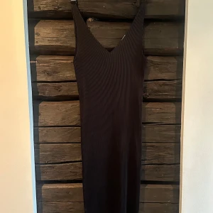 Svart småplisserad långklänning By Malene Birger - Supersnygg svart långklänning från By Malene Birger i småplisserat satintyg och v-ringning. Klänningen är ärmlös och har en slits nertill för extra rörelsefrihet. Perfekt för dig som gillar stilrena och minimalistiska plagg med en modern touch. Nypris 2000 sek. Aldrig använd. 