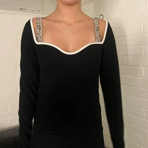 Svart långärmad topp med vit kant😚☺️ - Säljer en svart långärmad topp med snygg vit kant runt. En valing tröja med lite detalj. Pryderit för dig med en basic look men vill spica upp det lite. Köpt från H&M. Tröjan är ribbad svart. I storlek M. Passar till både fest och vardag. Perfekt fynd rakt in i garderoben. Skickar väldigt snabbt, så hojta till! Kommer från ett bra hem! 😆😚