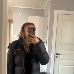 Svart pufferjacka från Calvin Klein Jeans - Svart pufferjacka från Calvin Klein Jeans med luva. Jackan är snygg och varm men säljer den pågrund av att den blivit förliten❣️
