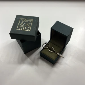 Chaos queen earring från Maria Nilsdotter - Unikt örhänge i silver från Maria Nilsdotter med två ringar och en spetsig hängande detalj. Snyggt och edgy design som sticker ut, levereras i orginal ask. 