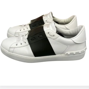 Valentino Open sneakers svart/vit skinn intressekoll! - Snygga Valentino Open sneakers i vitt skinn med bred svart rem över mitten och ikoniska nitar på hälen. Klassisk rund tå, vita snören och låg profil. Perfekta för dig som gillar stilrena och lyxiga detaljer. Inget fast pris, helt nya i skick.