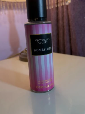 Victoria's Secret Bombshell parfym - En snygg parfym från Victoria's Secret i doften Bombshell. Flaskan är cylinderformad med rosa och ljusrosa ränder samt svart lock. Rymmer 250 ml och har en modern, feminin design som sticker ut på hyllan.