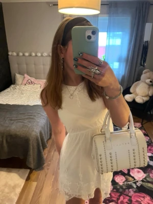 Vit spetsklänning med broderi - Söt vit kortklänning med broderade spetsdetaljer och ärmlös design. Klänningen har en feminin passform och lätt utsvängd kjol, materialet känns lätt och luftigt. Jag är 170 cm lång så den är för kort för mig (den är i st 158) 🤍🤍