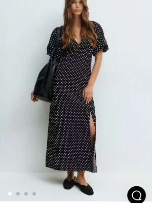 Svart prickig långklänning med slits - Prickig klänning från Gina i storlek 36. Endast använd en gång💓