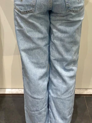 Levis -ljusblå - Säljer ett par ljusblå jeans med rak passform och klassiska bakfickor. Jeansen har hög midja och är tillverkade i denim med en avslappnad look. Perfekta för en chill och trendig stil.