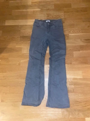 Grå bootcut jeans - Snygga grå jeans med bootcut-modell. Jeansen har klassisk femficksdesign och är tillverkade i ett mjukt jeanstyg. Perfekta för dig som gillar en avslappnad och trendig stil.