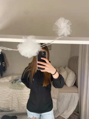 Svart vindjacka från lager 157 - Snygg svart vindjacka från lager 157 med dragkedja framtill och diskret logga på bröstet. Jackan har en enkel, stilren design och är tillverkad i ett lätt material som passar perfekt för blåsiga dagar.