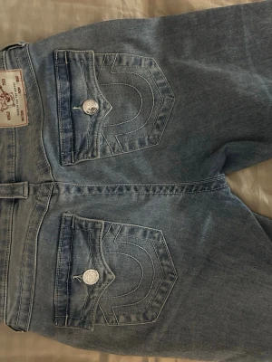 True Religion bootcut jeans ljusblå - Säljer ett par ljusblå bootcut jeans från True Religion.( har klippt dem där nere så dem är några cm kortare)
