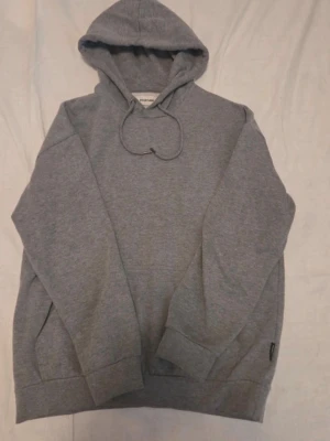 Grå hoodie från YOURTURN - Klassisk grå hoodie från YOURTURN med huva och dragsko. Mjuk bomullsblandning, stor magficka framtill och ribbade muddar vid ärmar och nederkant. Perfekt för en chill och avslappnad stil.