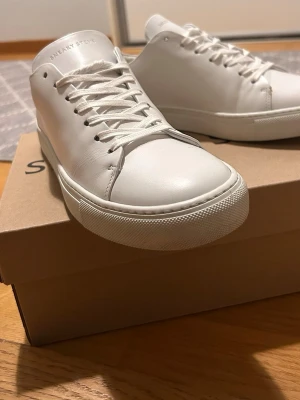 Sneaky Steve vita lädersneakers - Klassiska vita sneakers från Sneaky Steve i modellen Moore. Använda 3 gånger, köpta för 2 veckor sedan. Säljer för att de va aningen för små för mig. Storlek 41. 