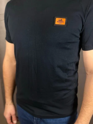 Svart t-shirt  - . Tillverkad i mjuk bomull som känns skön mot huden. Perfekt för en stilren och trendig look.