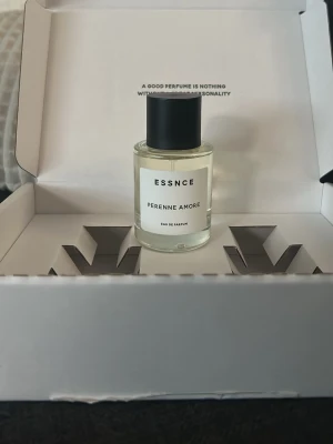 ESSNCE Perenne Amore Eau de Parfum - Minimalistisk parfymflaska från ESSNCE med doften Perenne Amore. Flaskan är genomskinlig med svart cylinderformad kork och vit etikett med svart text. Levereras i en stilren vit förpackning. Perfekt för dig som gillar enkel och modern design testad en gång.