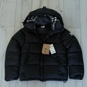 Burbery vinter jackaXväst - Snygg svart Burberry vinterjacka i storlek M, passar även S. Använd endast ett fåtal gånger och i mycket fint skick. Klassisk design med exklusiva detaljer och hög komfort – perfekt för både vardag och stad. Nypris betydligt högre.  Säljes nu för 1499 kr. ⏳ Först till kvarn. ❓ Har du frågor är det bara att höra av dig! 📏 Storlek M (passar även S).