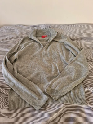  Rvls Grå halfzip tröja  - Snygg grå stickad tröja från Rvls med halv dragkedja och hög krage. Tröjan har långa ärmar och ribbade muddar vid ärmslut och nederkant. Perfekt för lager-på-lager och enkel att matcha med jeans eller chinos. Känns som en 167 i storleken