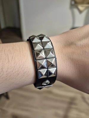 Armband punk pyramidnitar - Armband punk med pyramidnitar. Punk gothic style. Dubbelradigt kvadratiskt PU-läderarmband. Hip-hop, rock Musik festival, party, pararmband. Längd 22 cm. Bredd 2,8 cm.
