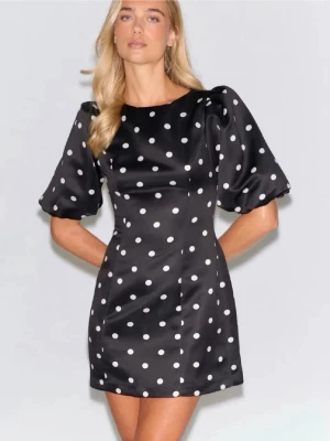 Svart miniklänning med puffärm Gina Tricot - Använd en gång. Snygg svart miniklänning med vita prickar och trendiga puffärmar. Klänningen har rund halsringning och är figurnära i modellen. Materialet ser glansigt ut och ger en lyxig känsla. Perfekt för dig som gillar retrovibbar och vill sticka ut.