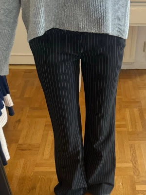 Svarta randiga kostymbyxor wide fit - Snygga svarta kostymbyxor med smala v Byxorna har låg som ger en cool och trendig siluett. Perfekta att styla med sneakers eller klackar för en modern look.